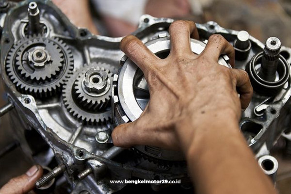 Mekanik Bengkel Motor 29 memperbaiki kerusakan mesin motor sebagai bagian dari layanan servis motor panggilan.